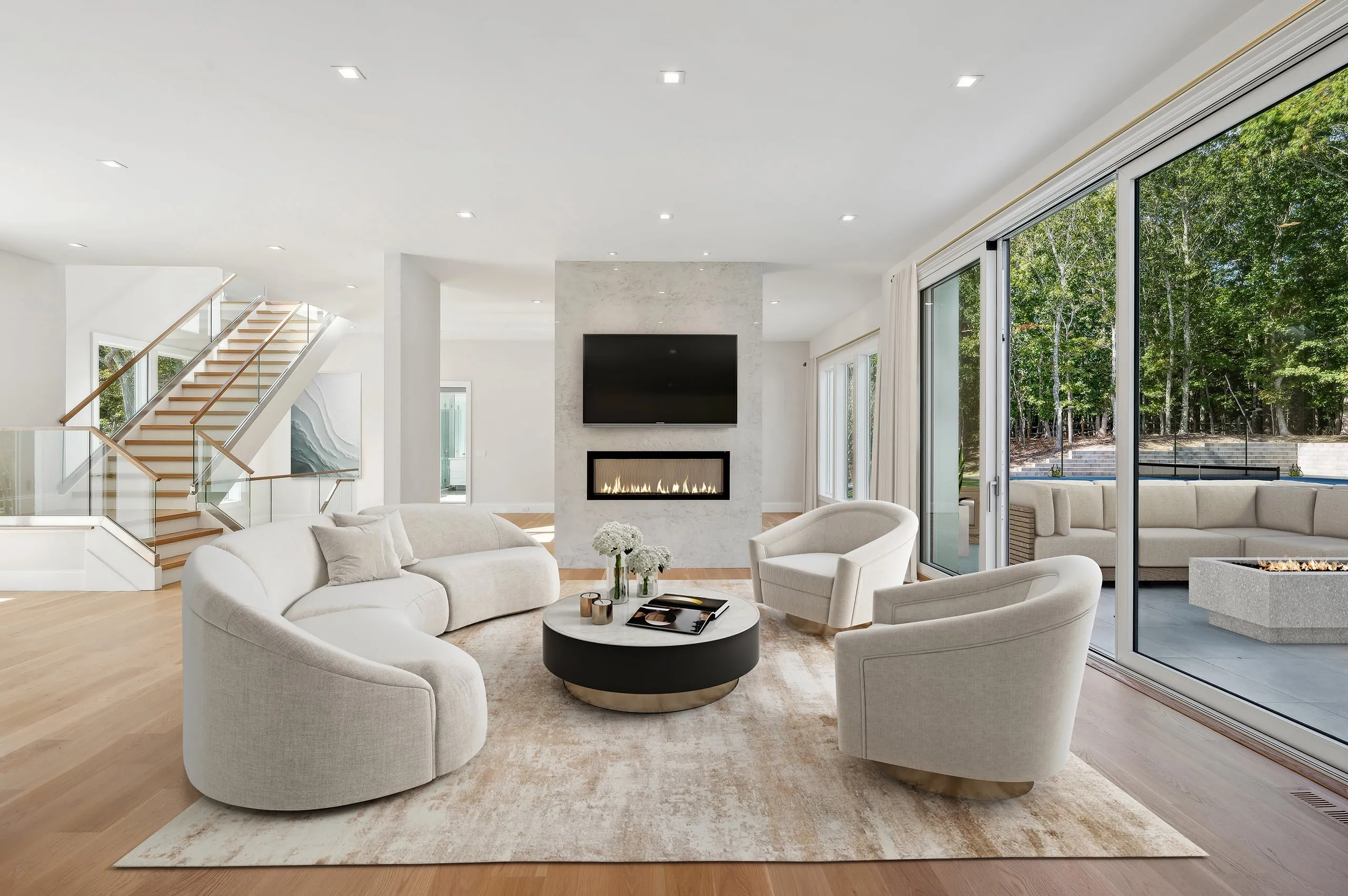 Staged living room with curved seating and a marble fireplace