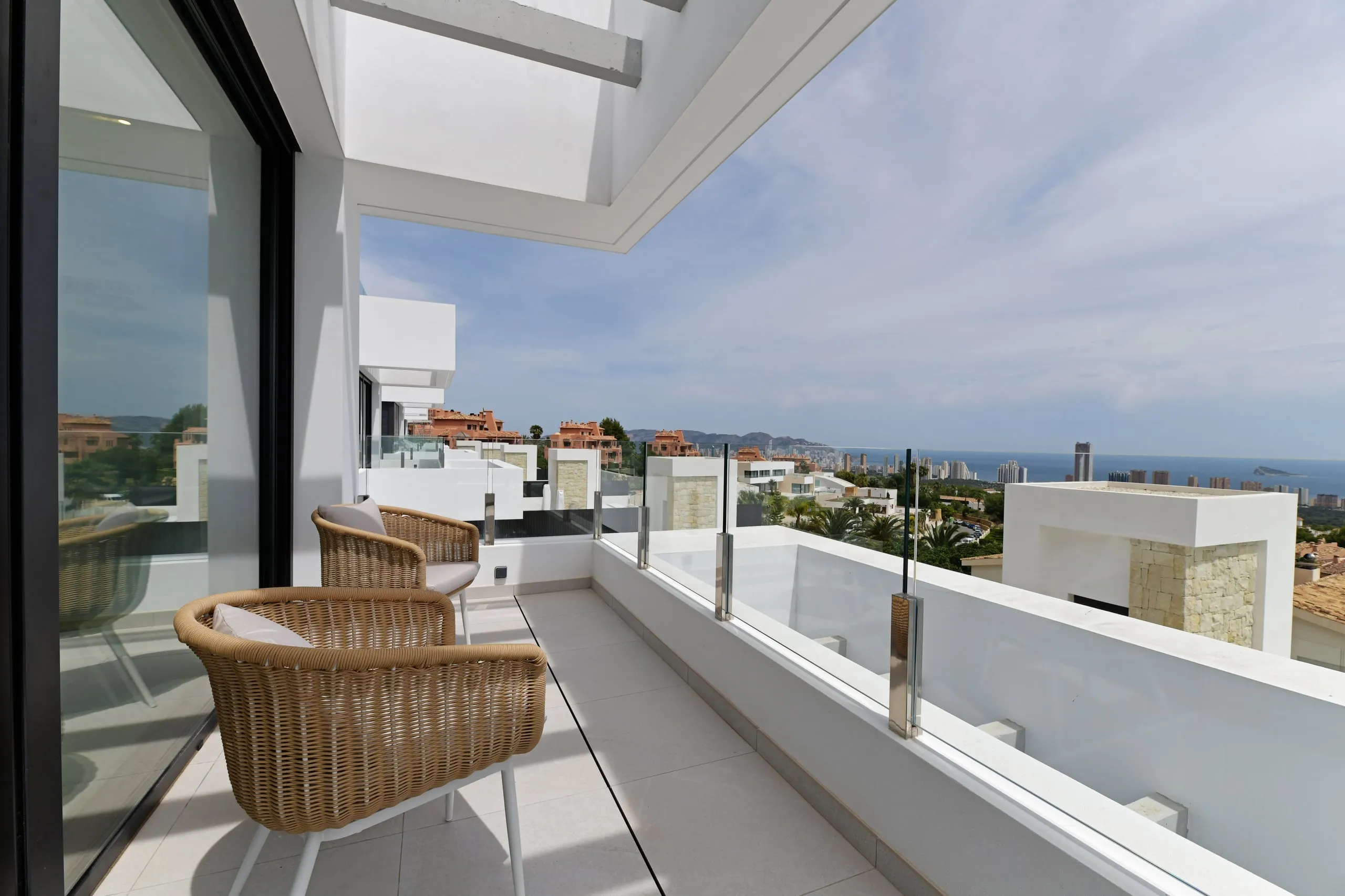 Balcony with wicker chairs overlooking the coast